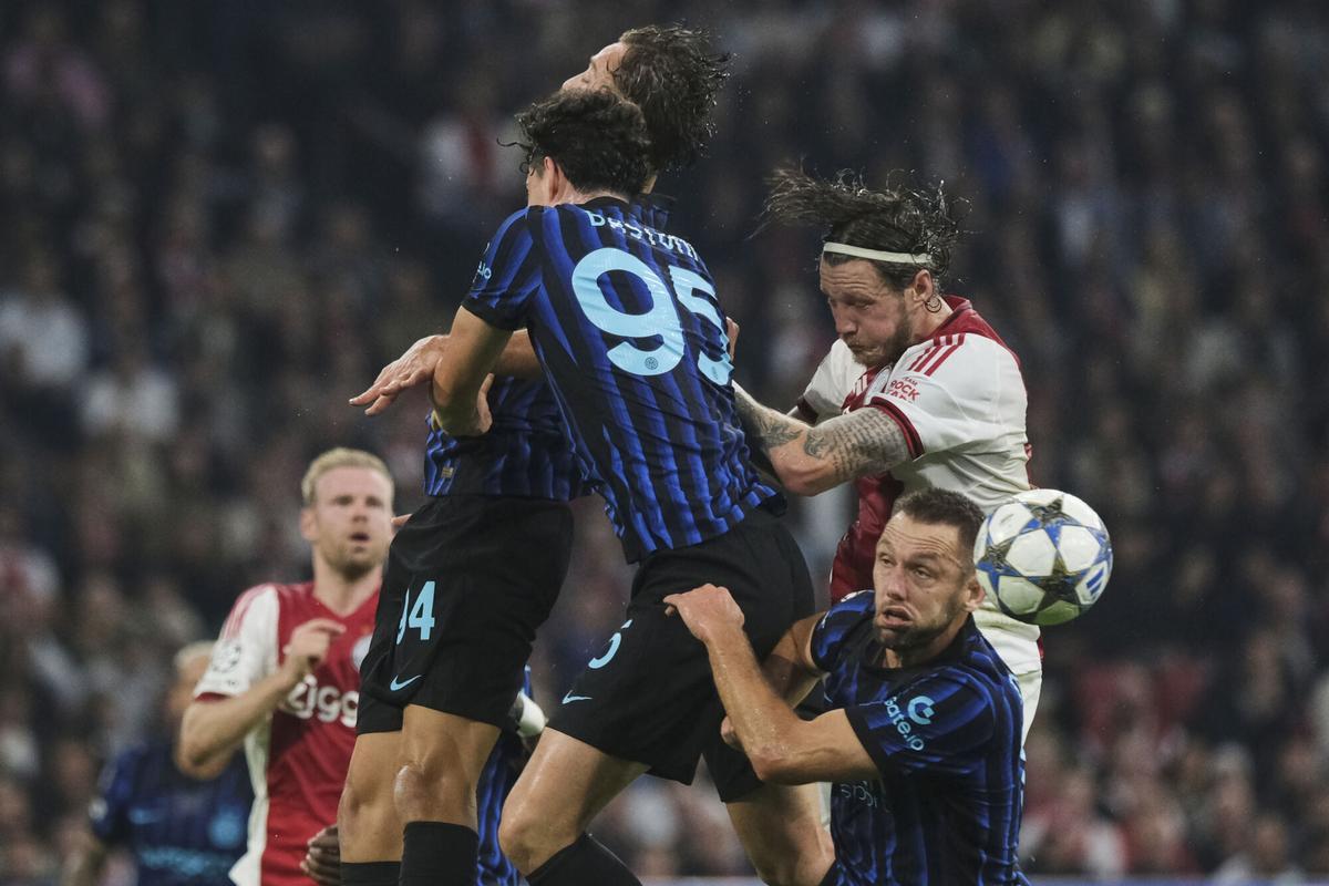 Inter Milan's Francesco Pio Esposito, center rear, Alessandro Bastoni, center, and Stefan de Vrij, bottom right, and Ajax's Wout Weghorst, top right, jump to head the ball during a Champions League opening phase soccer match between Ajax and Inter Milan at the Johan Cruyff ArenA in Amsterdam, Netherlands, Wednesday, Sept. 17, 2025. (AP Photo/Patrick Post)
