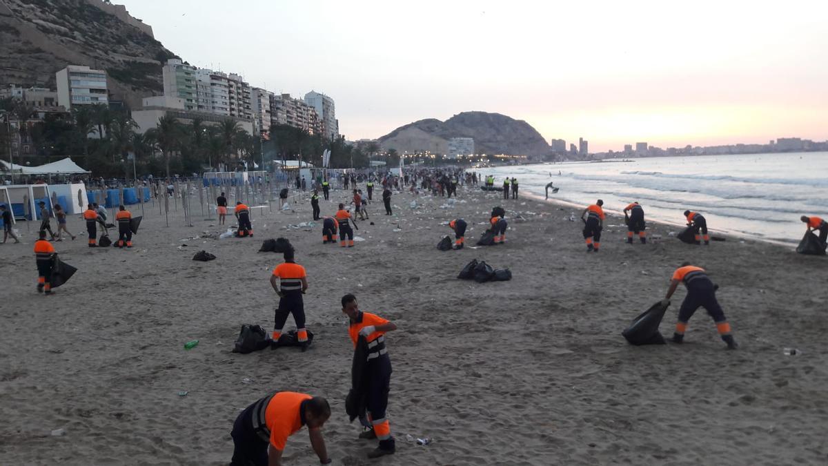 Limpieza de la playa del Postiguet, amaneciendo, tras la noche de fogatas