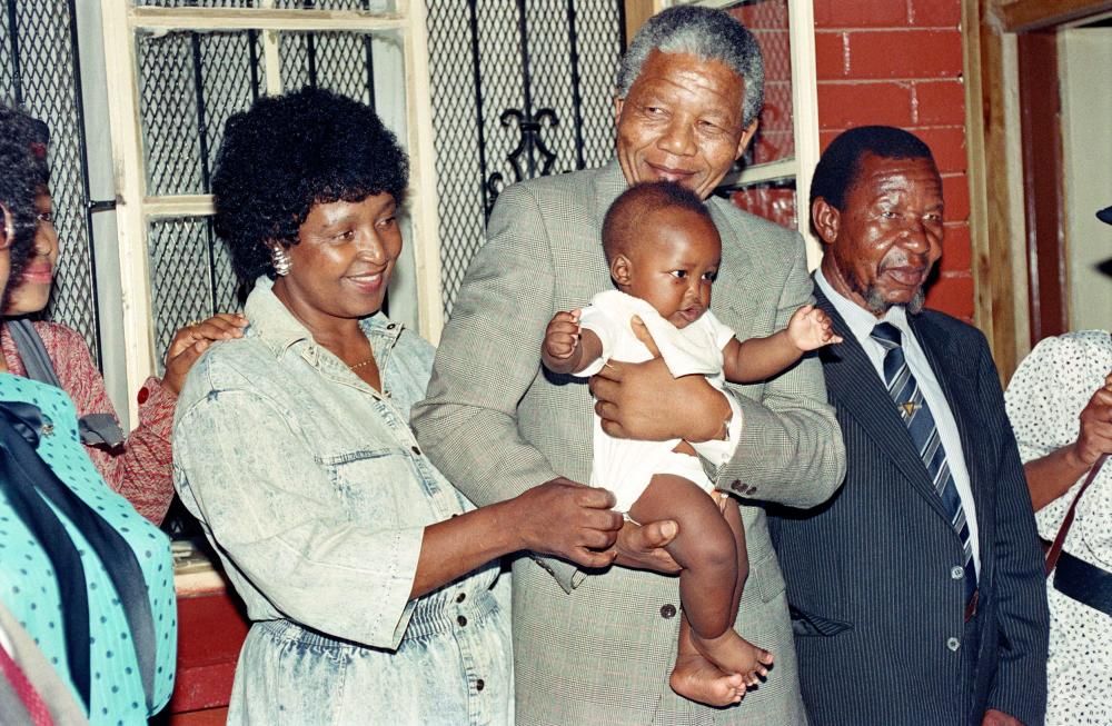 Nelson y Winnie Mandela con su nieto Bambata en su casa de Soweto en 1990. AFP PHOTO / WALTER DHALDHLA