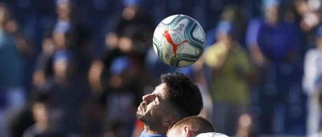 Dos jugadores disputan un balón aéreo en un partido reciente de fútbol profesional. // FdV