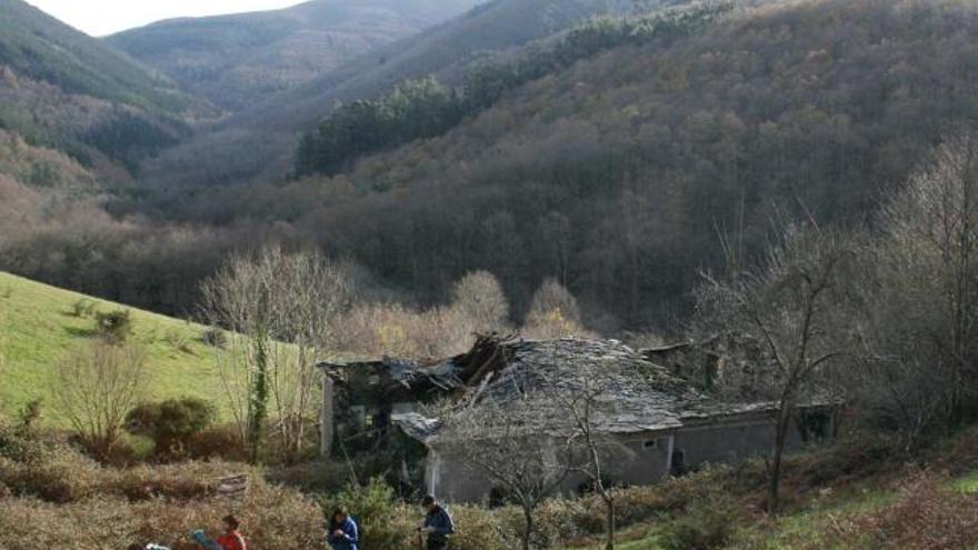 Un grupo de excursionistas camina por el entorno de A Cabanada, junto al caserío.