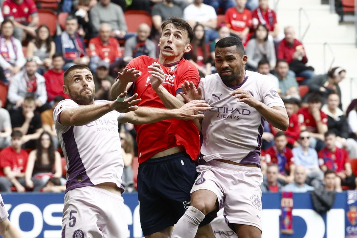 PAMPLONA, 13/04/2025.- El delantero croata del Osasuna Ante Budimir (c) con los jugagores del Girona Yangel Herrera (d) y David Lopez (i), durante el partido que disputan, este domingo, en el estadio de El Sadar, correspondiente a la jornada 31 de Laliga. EFE/ Jesús Diges H