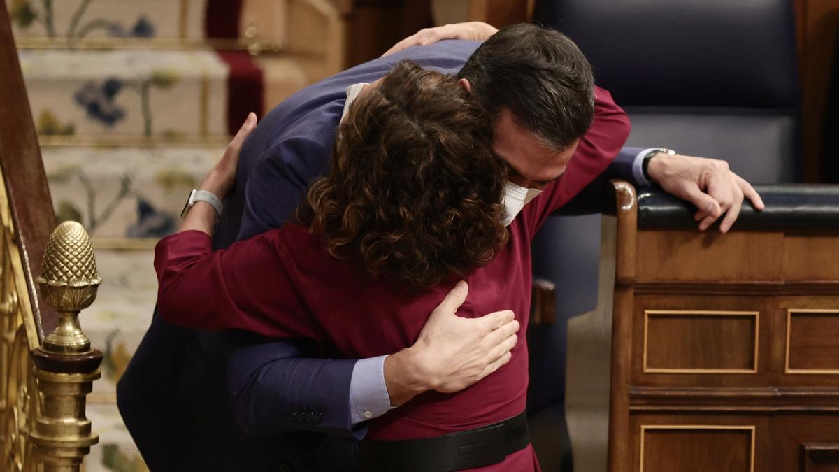 Ministerpräsident Pedro Sánchez und Finanzministerin María Jesús Montero fallen sich nach der Verabschiedung des Haushalts für 2022 in die Arme.