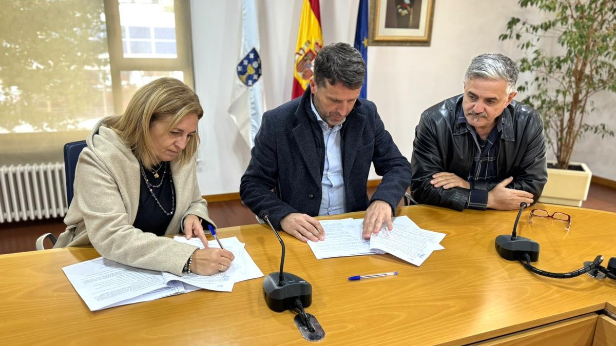 O alcalde, no centro, asinando o convenio coa representante de Boiro Voleibol.
