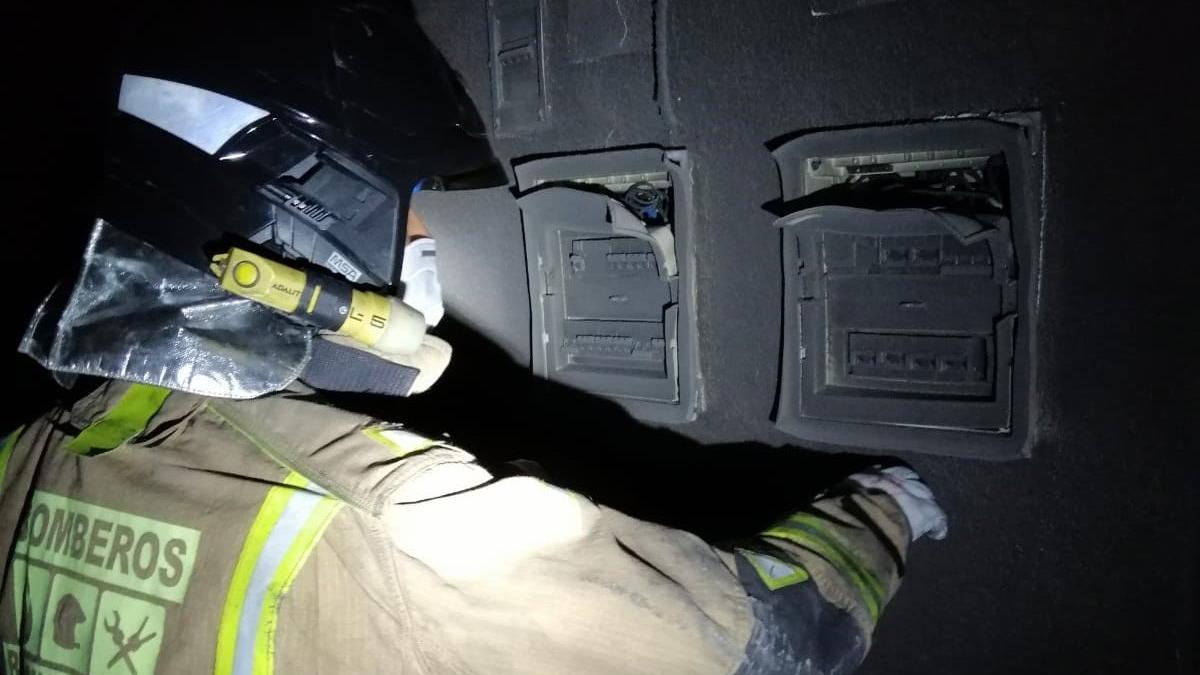 Un bombero inspeccionando los restos de un incendio en el Puerto de Mazarrón.