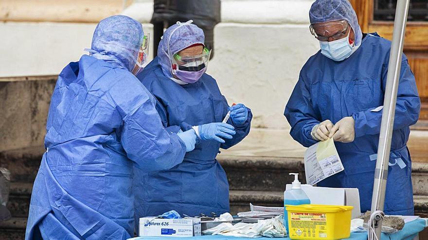 Tres sanitarios preparan pruebas de detección del coronavirus en el exterior del hospital de la Malvarrosa, en València.