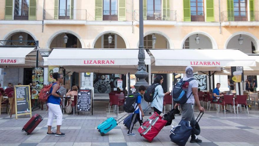 Un grupo de turistas pasea por la Plaza Mayor de Palma