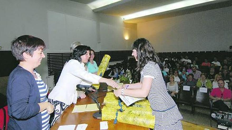 María Jesús Álvarez entrega el premio a una estudiante en presencia de María. F. Campomanes en La Felguera.