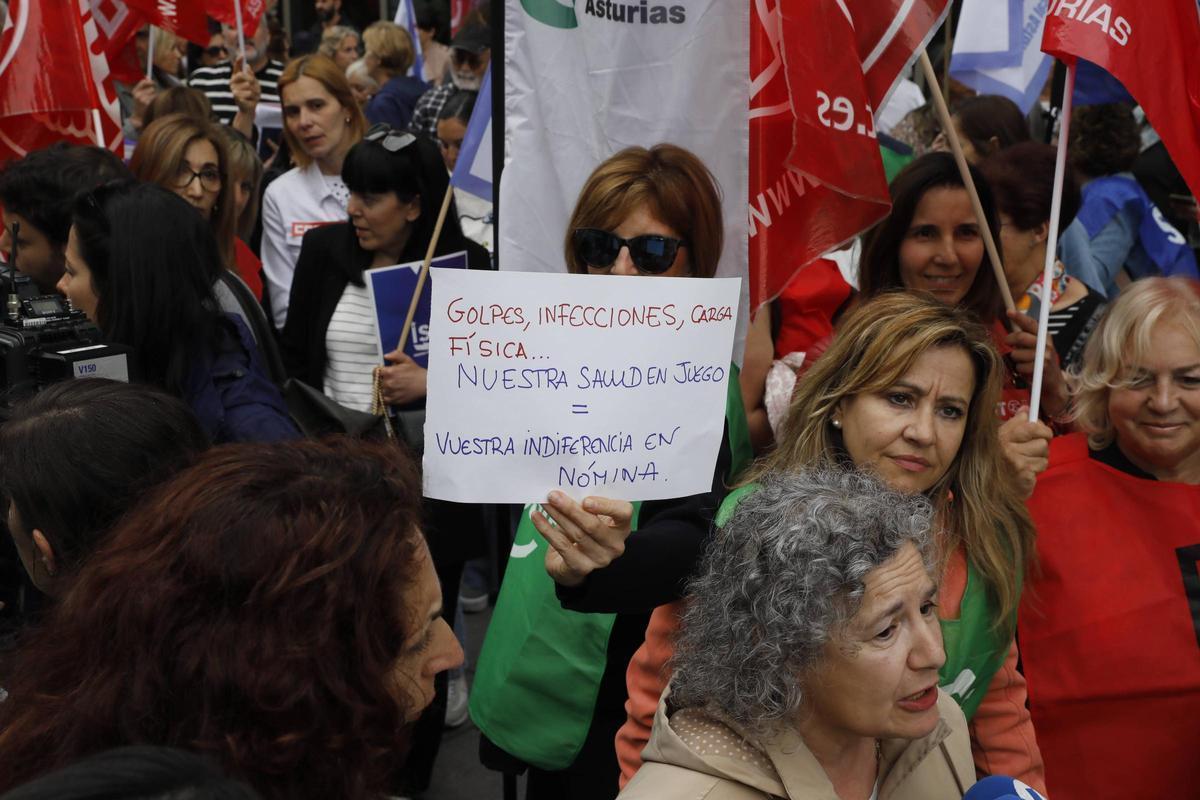 Una trabajadora con un cartel denunciando los riesgos que sufren, en una concentración en junio.