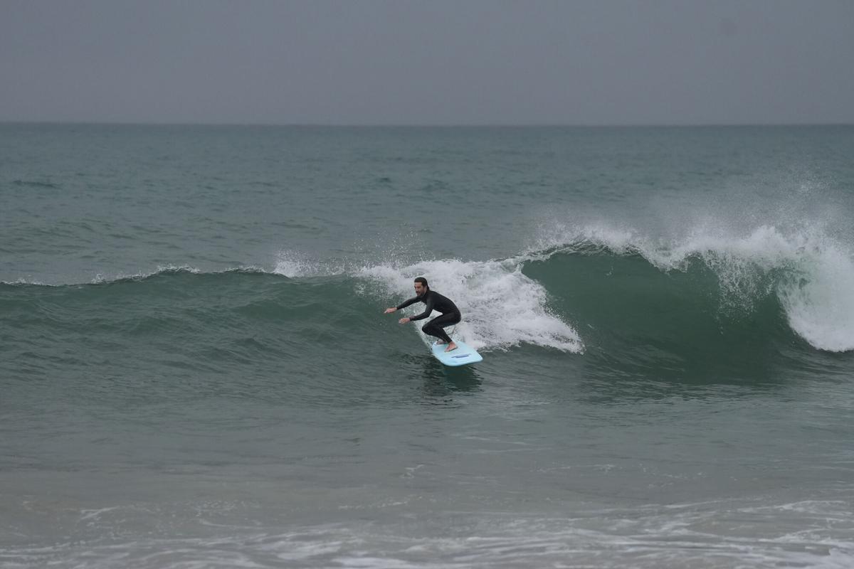 Un hombre practica surf durante el temporal, a 19 de enero de 2026, en Barcelona, Cataluña (España).
