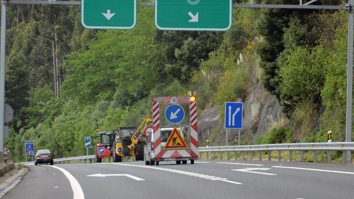 Limpieza, ayer, de la maleza en las márgenes de la autovía.