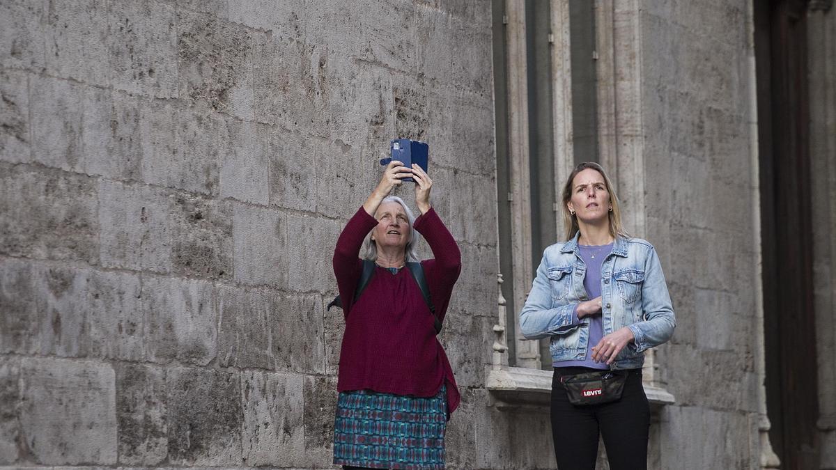 Una turista hace una foto en el centro de València.