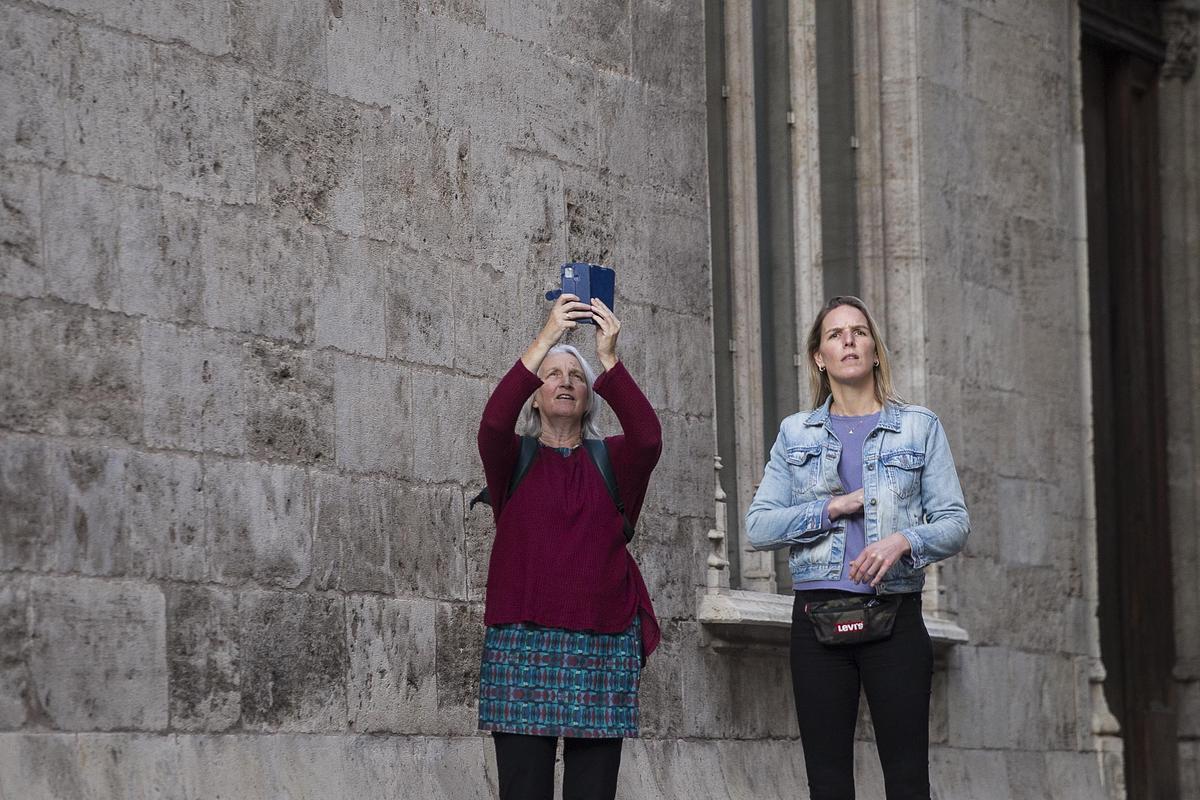 Una turista hace una foto en el centro de València.