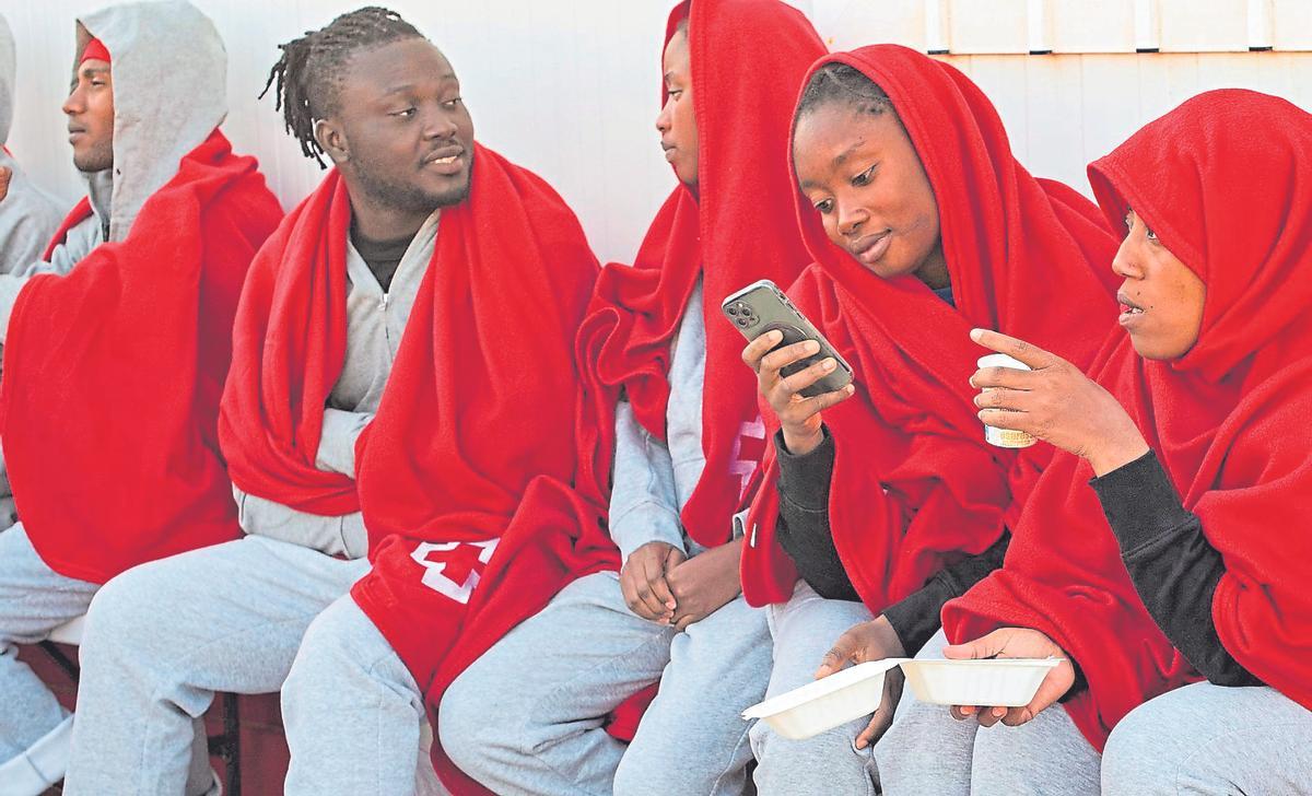 Una joven usa su teléfono móvil en Fuerteventura, tras ser rescatada a bordo de una patera.