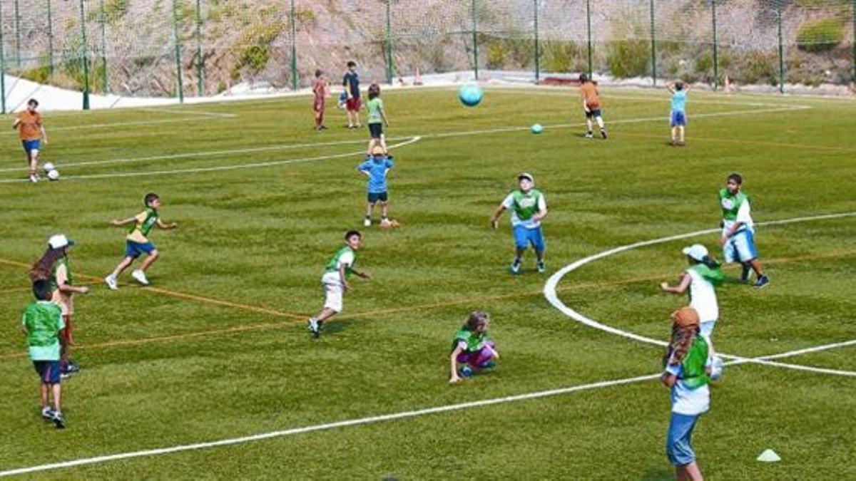 Niños y niñas se entrenan en el campo de fútbol del CEU Ciutat Meridiana.