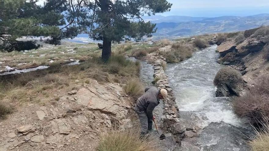 Acequiero de la Comunidad de Regantes derivando el agua de la acequia de Bérchules para su infiltración en la sima de las Arroyadas