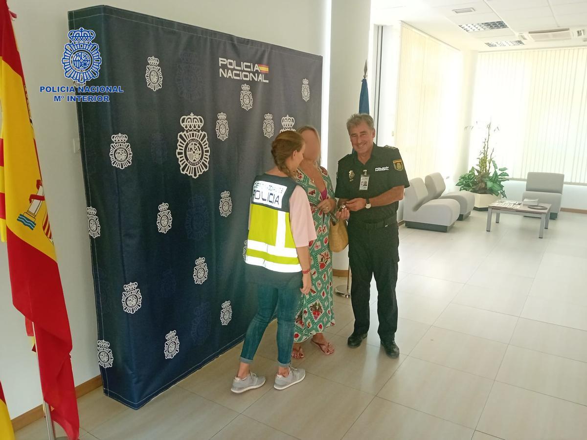 Un agente de la Policía Nacional entrega a la propietaria el reloj de lujo recuperado