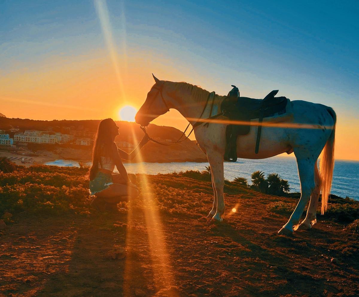 Mit dem Pferd am Strand im Sonnenuntergang
