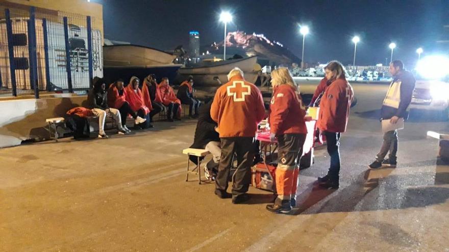 Un grupo de la Cruz Roja atiende, ayer, a los migrantes llegados al Puerto de Alicante.