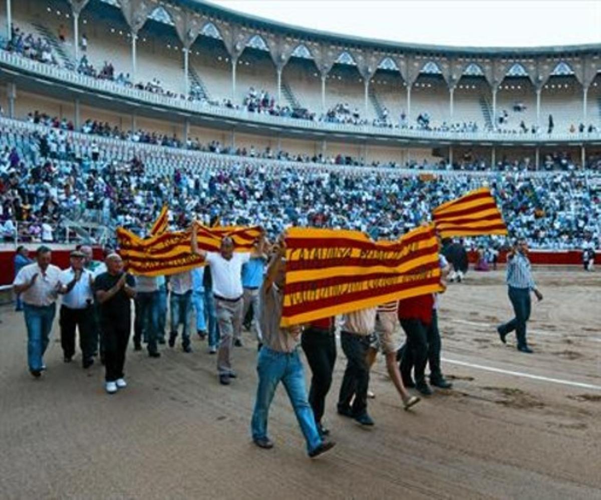 Diversos aficionats clamen contra el possible veto dels toros, ahir a la Monumental al final del passeig.