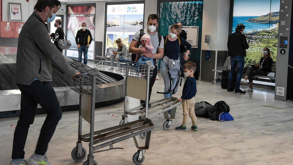 Turistas llegan al aeropuerto griego de Heraklion para iniciar sus vacaciones en la isla de Creta.