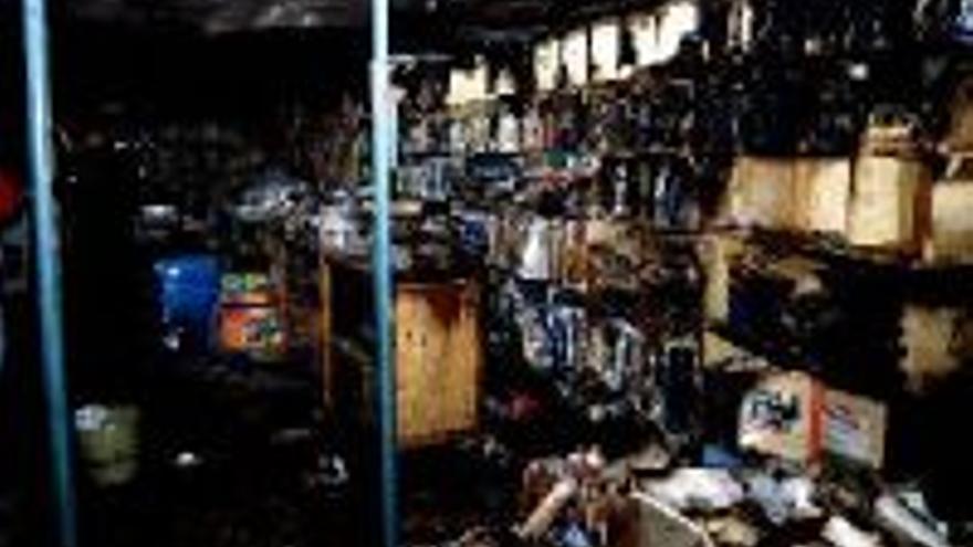 Un encapuchado prende fuego a una tienda que quedó arrasada