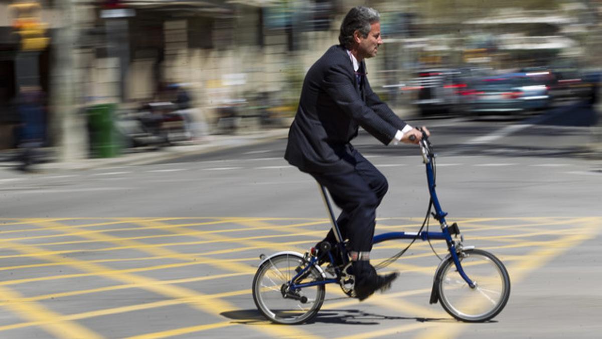 Un hombre pedalea en su bicicleta plegable, el modelo más aconsejado por los expertos, este martes, en València con Sant Joan.