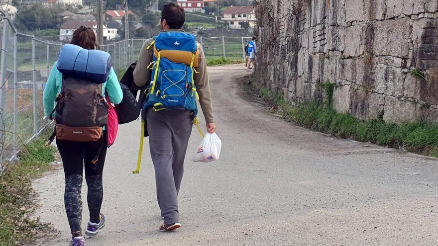 Peregrinos con sus mochilas en un tramo del Camino Portugués. // M.G.Brea