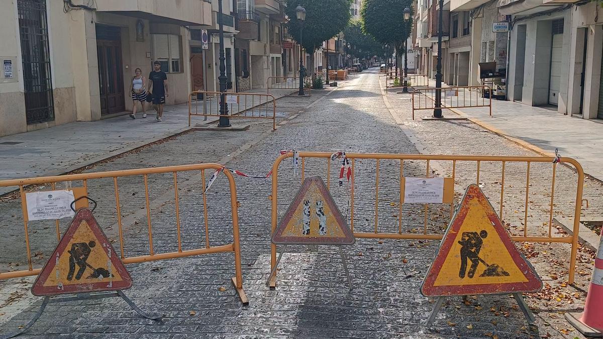 Señalización de obra en el carrer Mare de Déu de Sueca para comenzar los trabajos de renovación del pavimento.