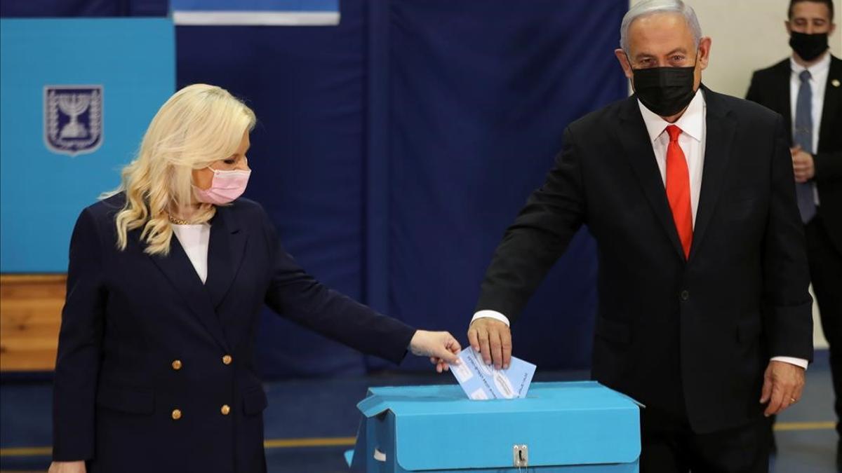 Israeli Prime Minister Benjamin Netanyahu and his wife Sara cast their ballots in Israel s general election  at a polling station in Jerusalem March 23  2021  REUTERS Ronen Zvulun Pool