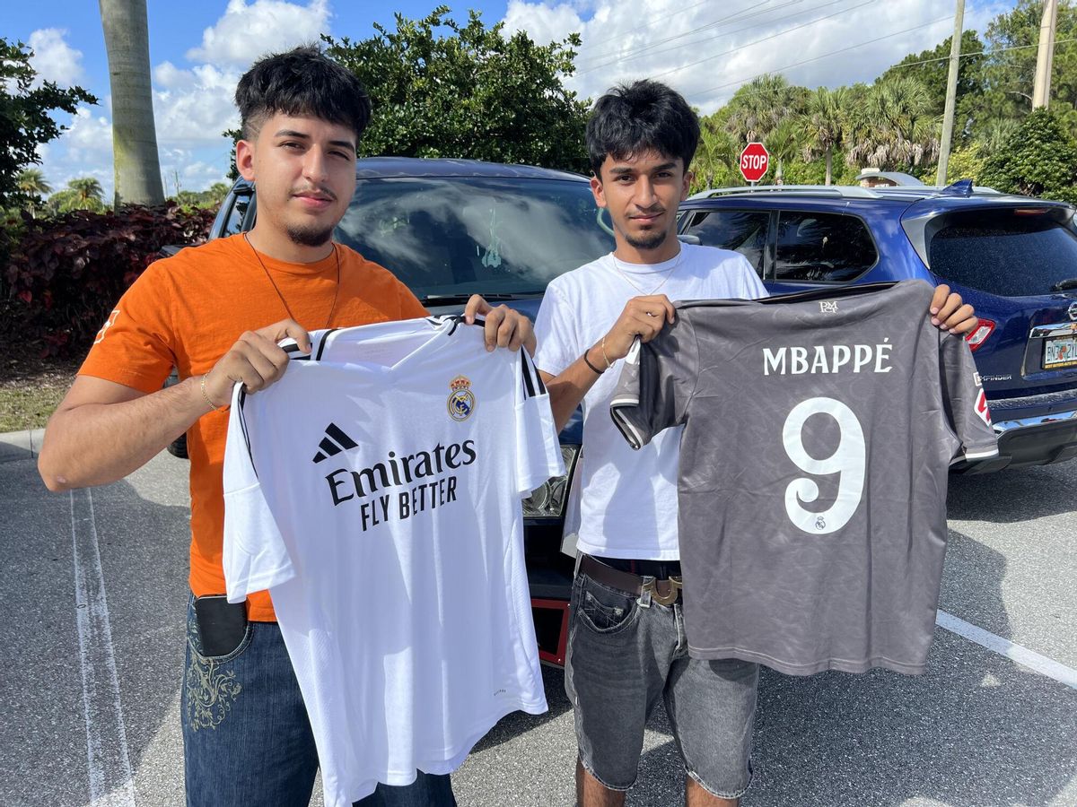 Dos aficionados del Real Madrid con camisetas a la entrada de la concentración blanca en Palm Beach.