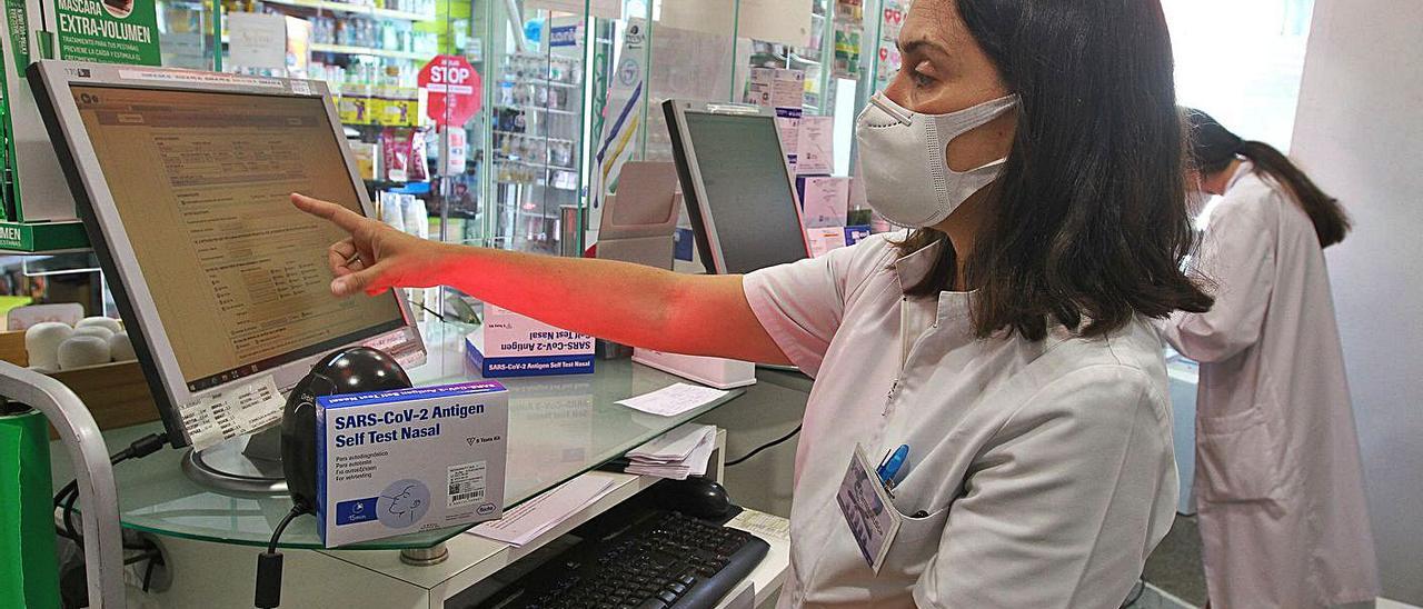 Una farmacéutica muestra el sistema de impresión de certificados COVID. |   // IÑAKI OSORIO