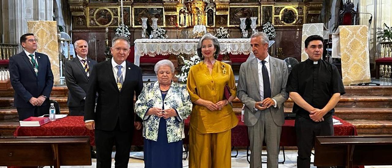 Las personas reconocidas por la cofradía posan ante el altar de la iglesia.