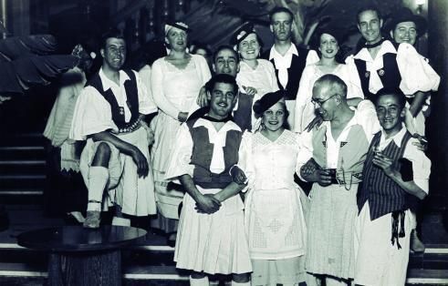 Néstor Martín Fernández de la Torre -segundo por la derecha en la primera fila- durante la presentación de su traje típico. La imagen se realizó mediante el uso de la técnica de gelatina bromuro 1934. Se encuentra en el Archivo de fotografía histórica de Canarias. Cabildo de Gran Canaria.
