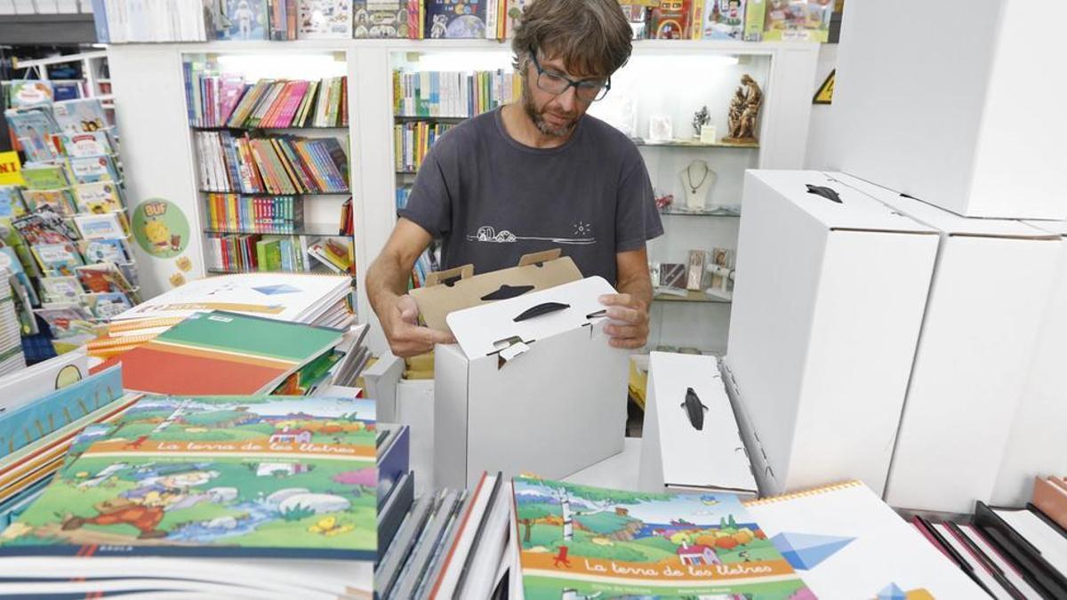 Un llibreter de la Llibreria Empúries de Girona, ahir preparant els lots. | ANIOL RESCLOSA