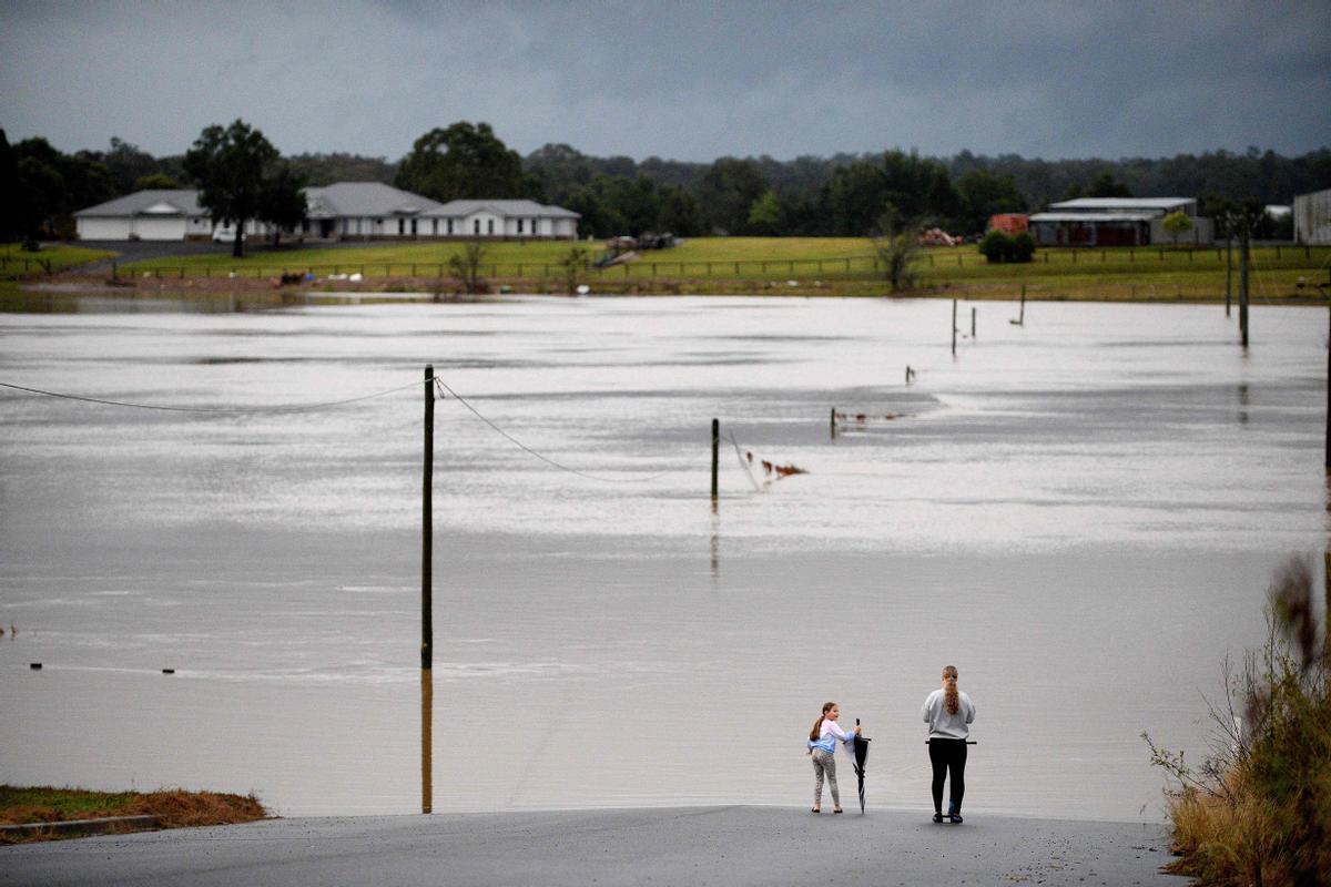 Residentes observan las inundaciones causadas tras desbordarse el río Hawkesbury, en el suburbio de Pitt Town, al noroeste de Sidney, Australia, el 6 de julio del 2022.