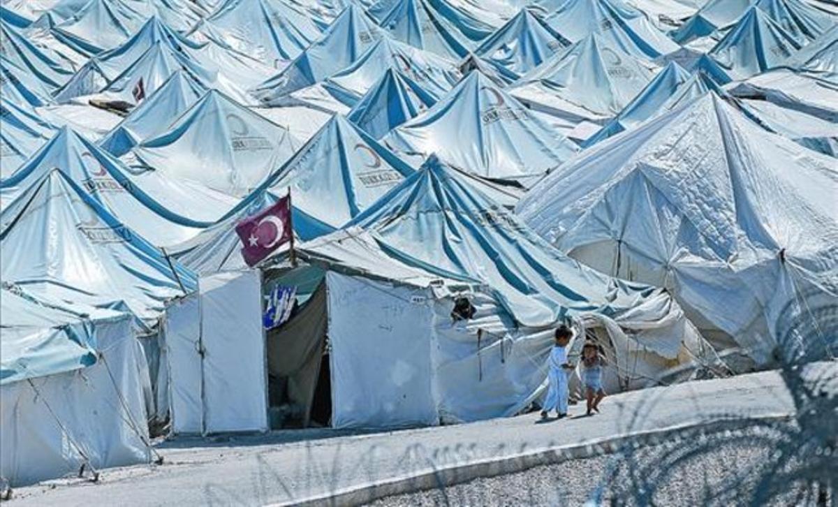 Dos nens caminen per un camp de refugiats de Yayladagi, a la província de Hatay, al sud de Turquia. Dos nens caminen per un camp de refugiats de Yayladagi, a la província de Hatay, al sud de Turquia.