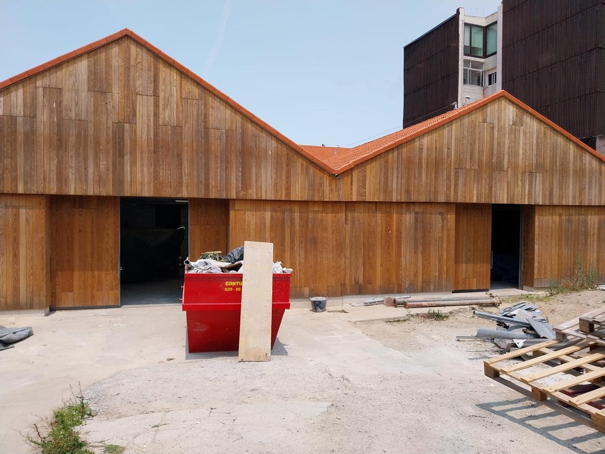 Las fachadas de las naves rehabilitadas en el Museo Massó, con sus portones de entrada con frente a la parcela propiedad del Concello de Bueu