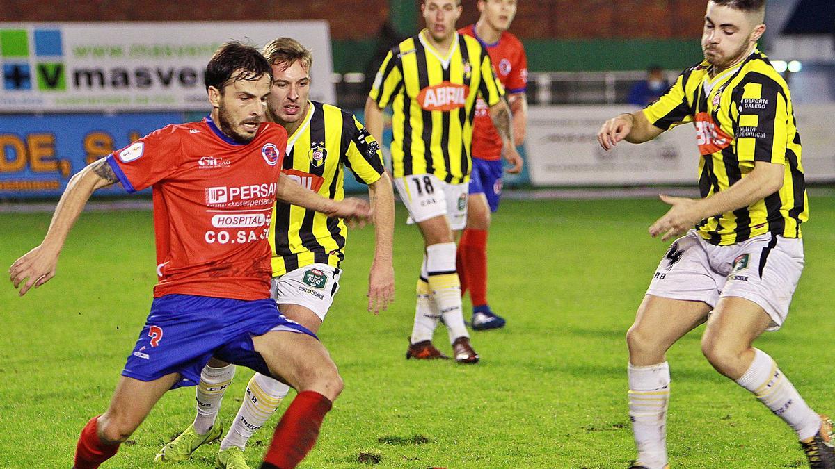 El lateral de la UD Ourense Alfredo Veiga disputa la pelota con dos rivales del Rápido de Bouzas, ayer en el campo de O Couto. |  // IÑAKI OSORIO