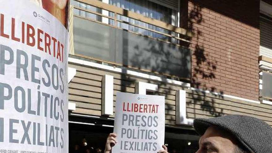 El vicepresidente de Òmnium, Marcel Mauri, pega un cartel por la libertad de Cuixart y el resto de los líderes soberanistas presos. // Efe