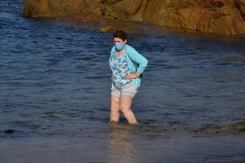 Los coruñeses que se acercan a las playas cumplen con la obligación de usar la mascarilla salvo para entrar en el agua.