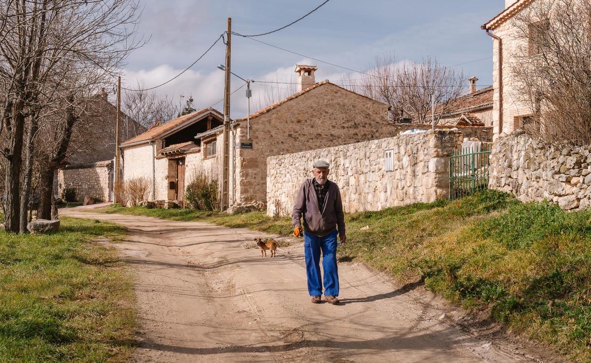 Uno de los vecinos de Tanarro, en Segovia, anda por una de las calles principales del pueblo, sin asfaltar.