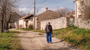 Uno de los vecinos de Tanarro, en Segovia, anda por una de las calles principales del pueblo, sin asfaltar.