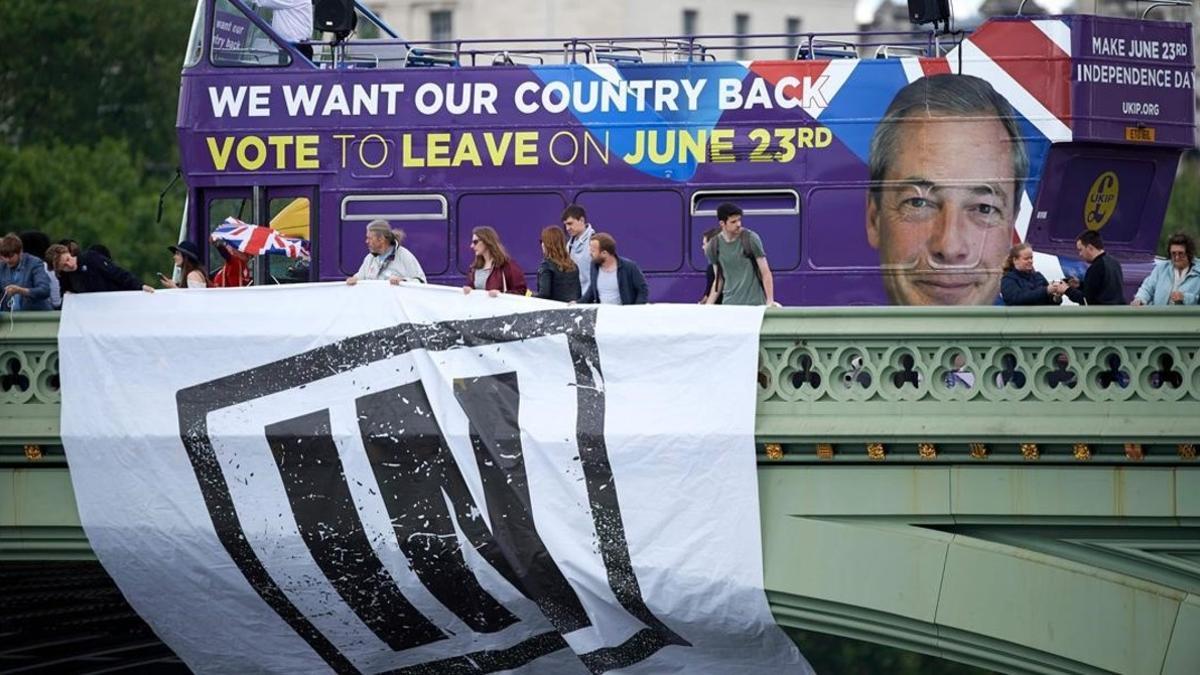 Un autobús con un cartel de la campaña por el 'Leave' y un cartel colgando de un puente por la opción 'Remain'.