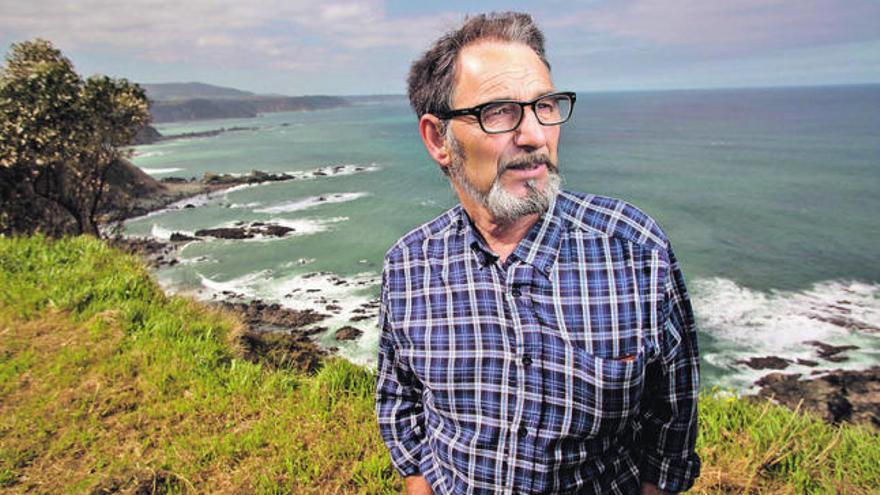 Antonio González posa con la costa de Muros de Nalón, el lugar donde naufragó, detrás de él. | ricardo solís