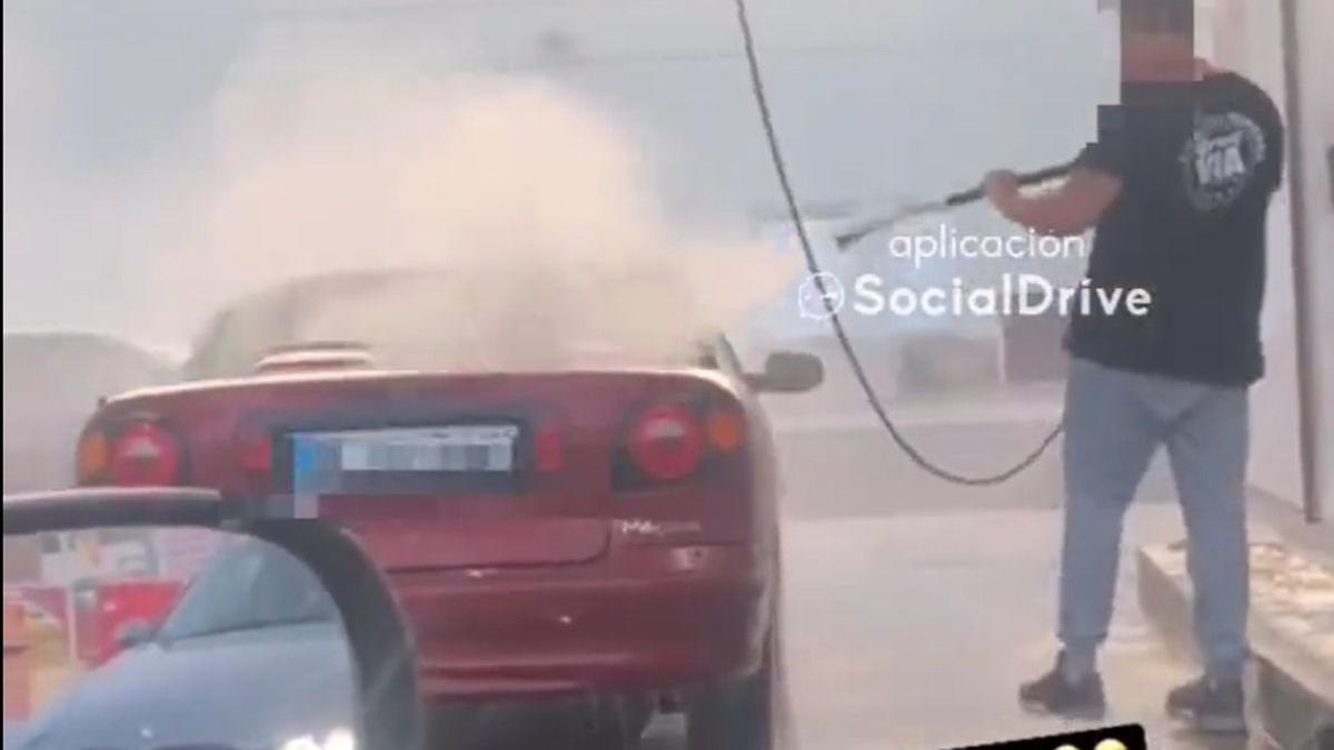 Momento en el que el hombre dirige el chorro de agua hacia los ocupantes del vehículo.