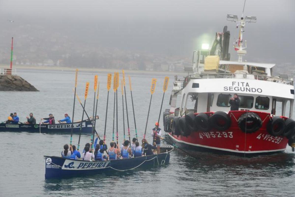 La tripulación mixta alza sus remos ante el barco bateeiro, tras completar la prueba prevista. |  // G.N.