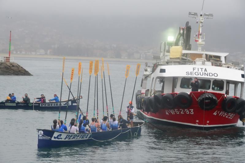 La tripulación mixta alza sus remos ante el barco bateeiro, tras completar la prueba prevista. |  G.N.