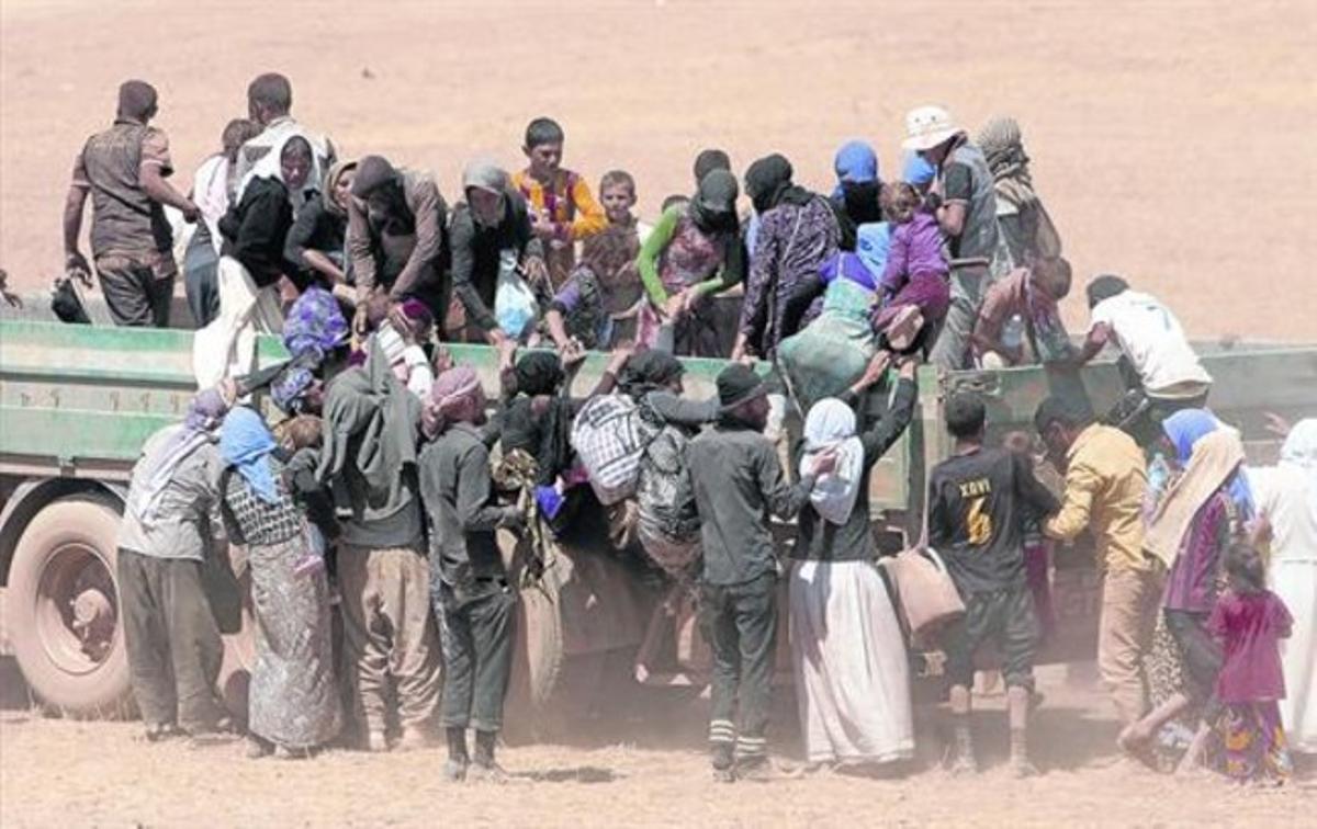 Refugiats yazidites que fugen dels gihadistes a l’Iraq pugen a un vehicle per anar a Síria. Refugiats yazidites que fugen dels gihadistes a l’Iraq pugen a un vehicle per anar a Síria.