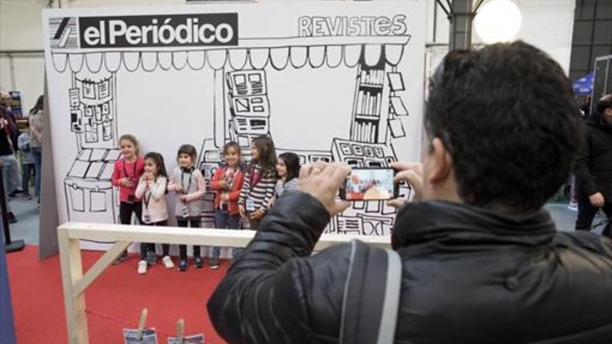 Haciendo portadas 8Unos niños posan para una foto en el quiosco de EL PERIÓDICO, ayer, en la jornada inaugural de La ciutat dels somnis.